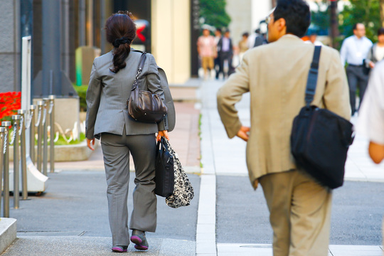 働く女性と男性の後ろ姿