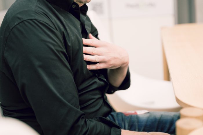 胸に手を当てる男性