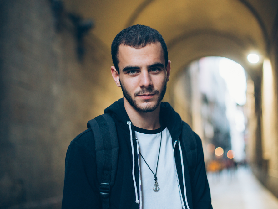 口を結んだまま笑顔を浮かべる男性