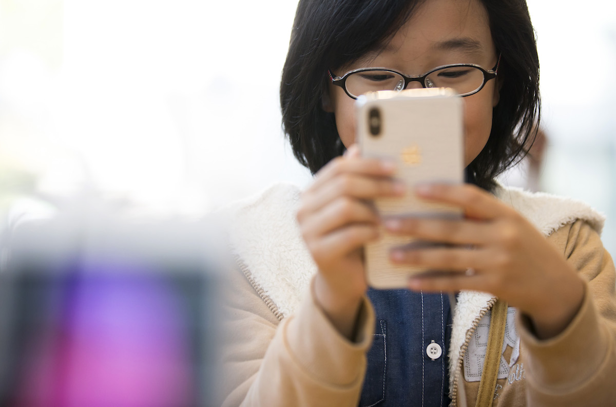 スマートフォンを見る子ども