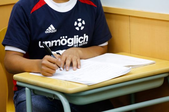 ノートに字を書く生徒