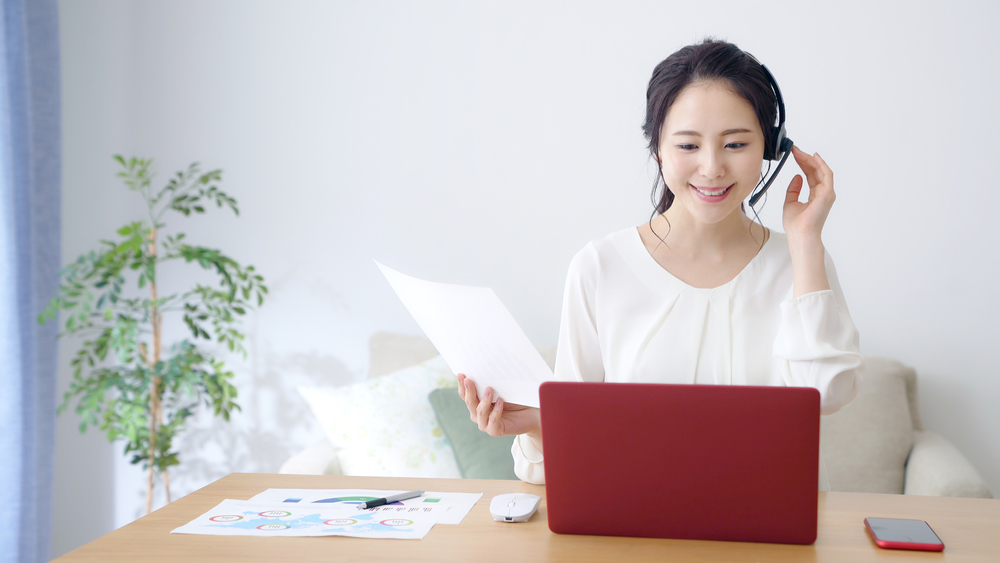 ヘッドセットをつけてオンライン会議に参加する女性