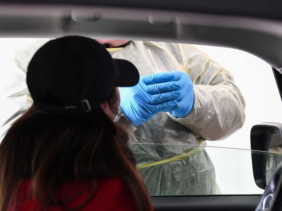 ドライブスルー型検査施設のメディアイベントで、拭き取り検査を行う医師。3月11日、ドイツ、ミュンヘンにて。
