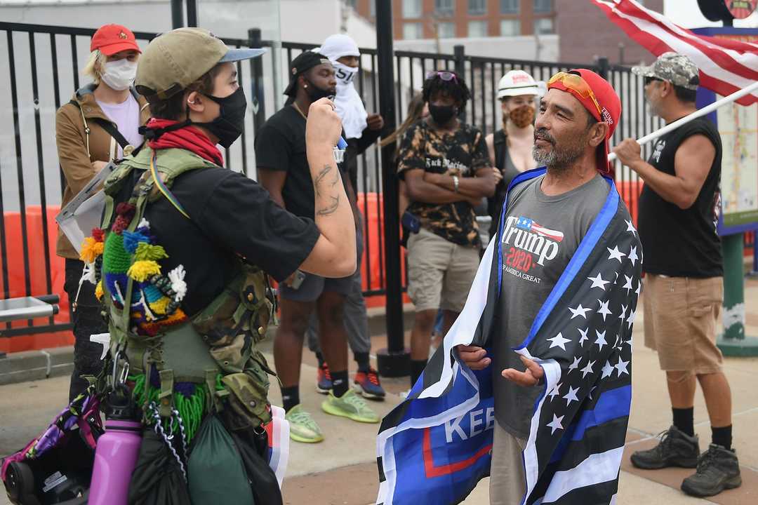 マスク姿でBlack Lives Matter（BLM）運動に参加する人（左）。対峙するのは、マスクを着けないトランプ支持者。2020年7月27日。ミズーリ州セントルイス。