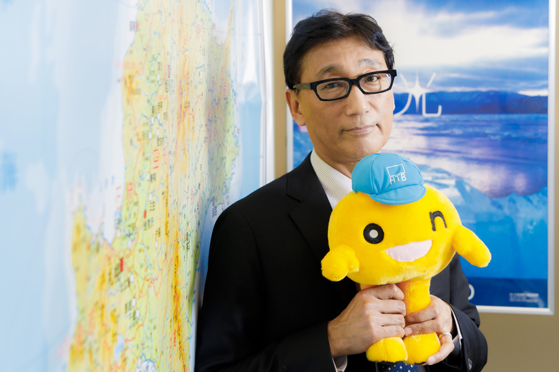 HTBのマスコット｢onちゃん｣を手にするHTB取締役兼東京支社長の福屋渉氏。福屋氏は｢キャップ｣の愛称で水曜どうでしょうファンにも知られた存在だ。