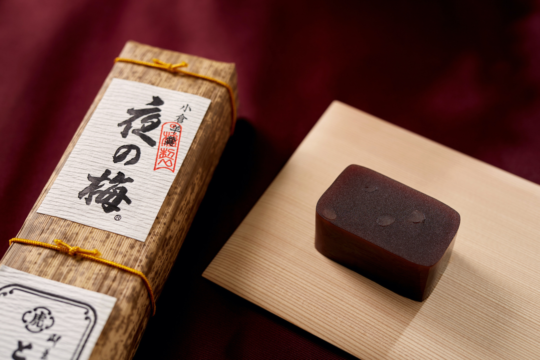 虎屋を代表する小倉羊羹｢夜の梅｣。切った断面に見える小豆の粒を夜の闇に咲く梅に見立ててつけられた銘。 菓銘は1694年（元禄7）の｢諸方御用之留｣に見ることができるが、羊羹としては1819年（文政2）の記録が最初。