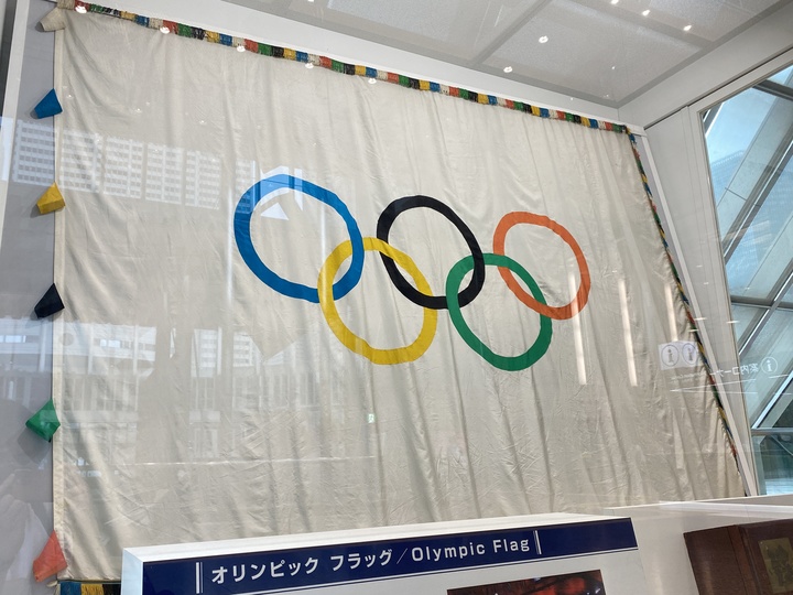 都庁に保管されているオリンピックフラッグ(五輪旗)。五つの輪のシンボルは、「近代五輪の父」クーベルタン男爵が1914年のIOC創立20周年式典で披露するために作ったと言われている。5つの輪は世界の五大陸を意味する。