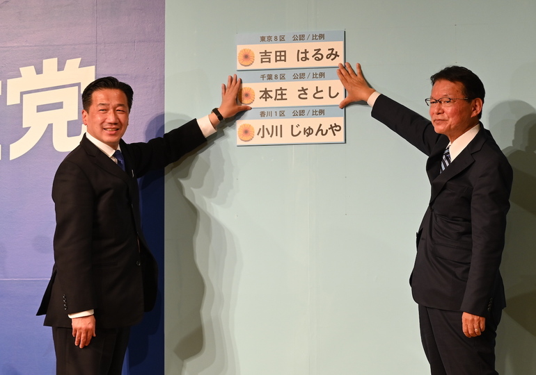当選確実が伝えられた議員の名前を張り出す立憲・長妻副代表(右)と福山幹事長