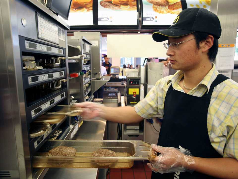 A McDonald's employee preparing burgers.