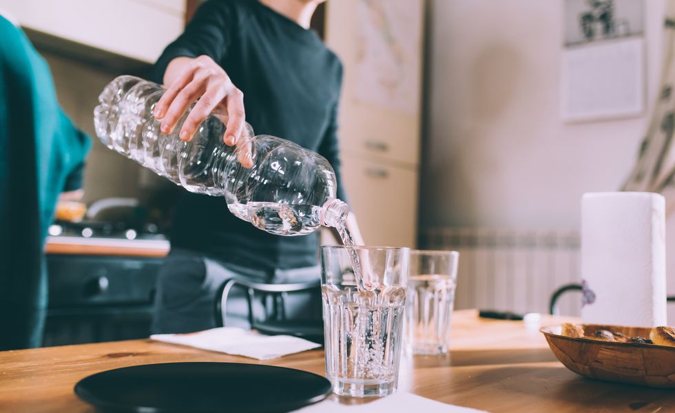 cropped-shot-of-young-woman-pouring-water-at-royalty-free-image-699089553-1543331131