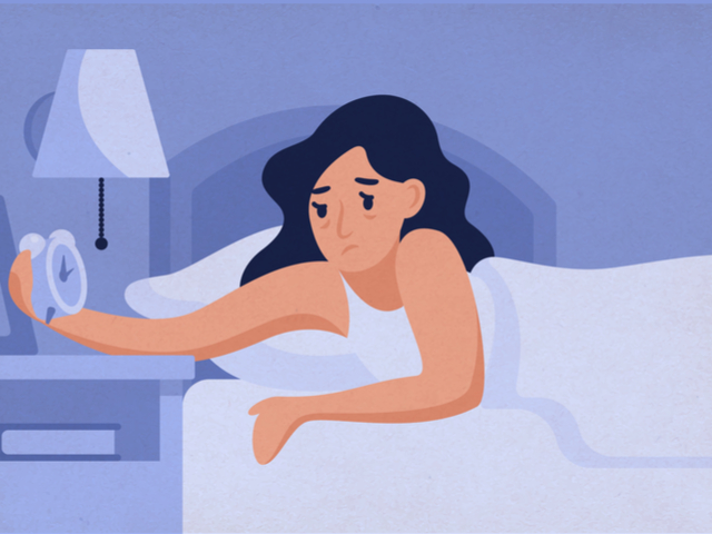 目覚まし時計を止める女性
