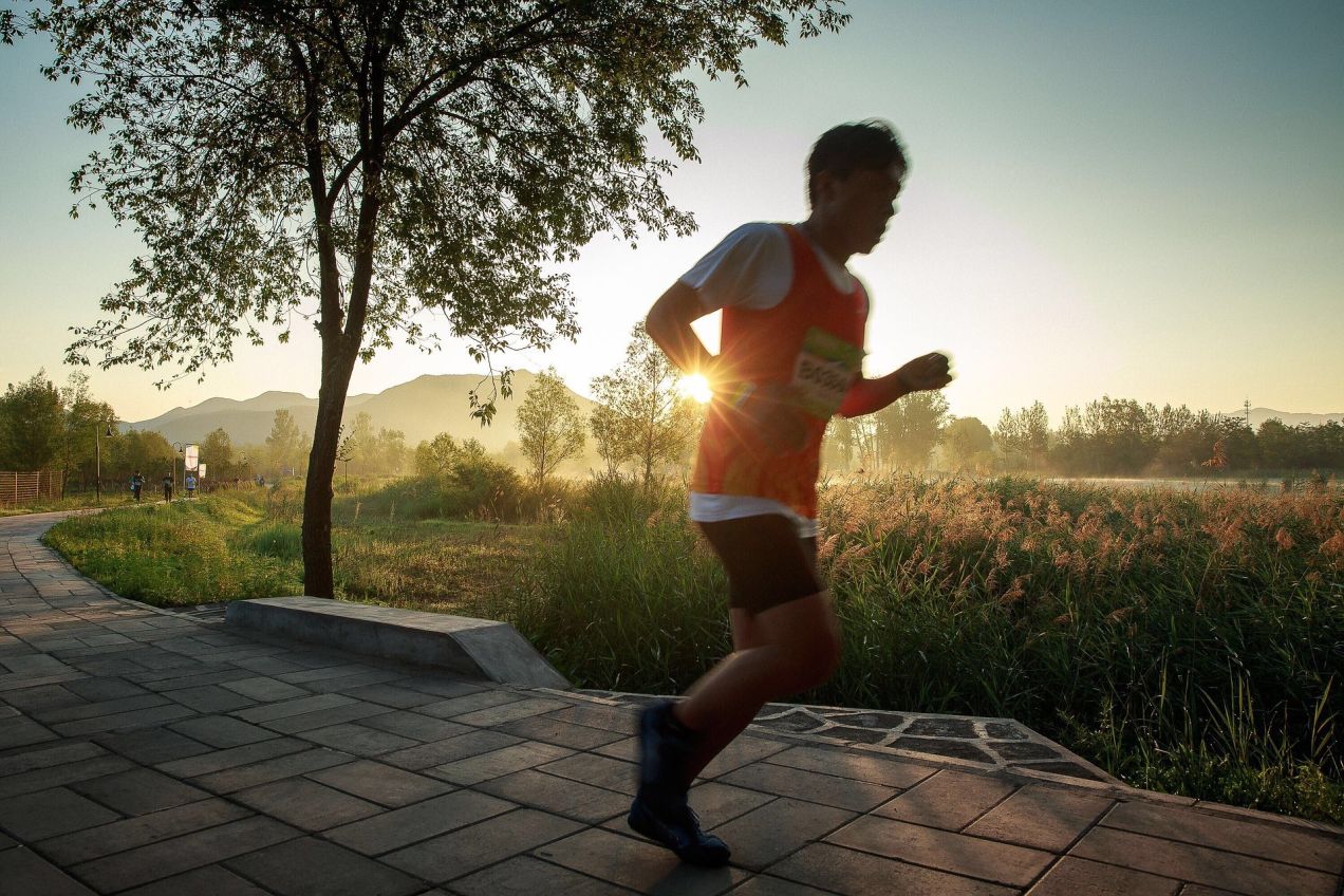 朝日を浴びながらランニングする男性