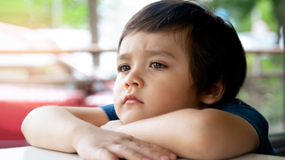 腕のうえに顎をのせる幼児