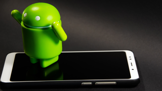 スマホの上に置かれたアンドロイドのマスコット