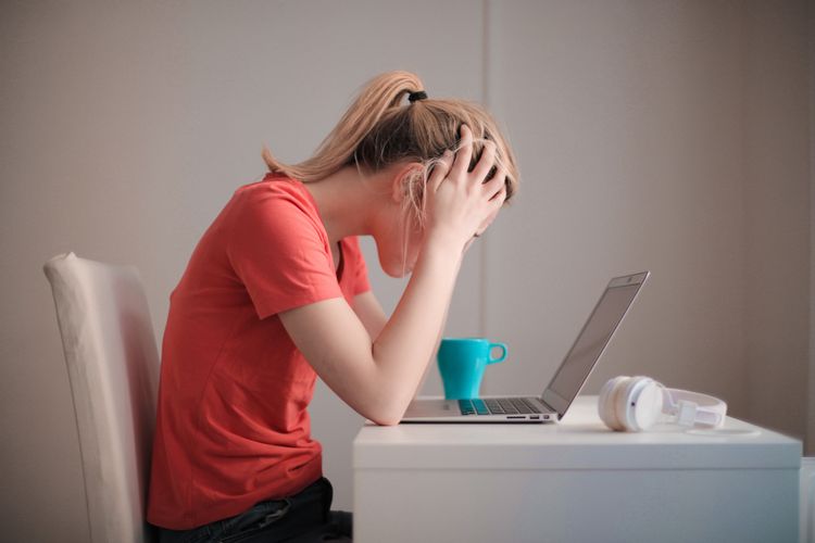 パソコンに向かって頭を抱える女性