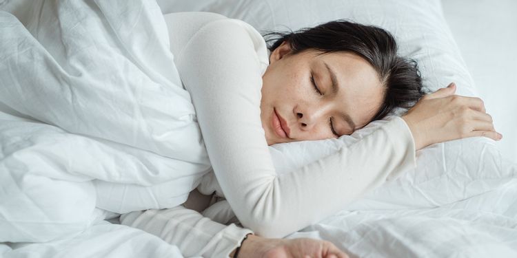 布団に入って眠る女性