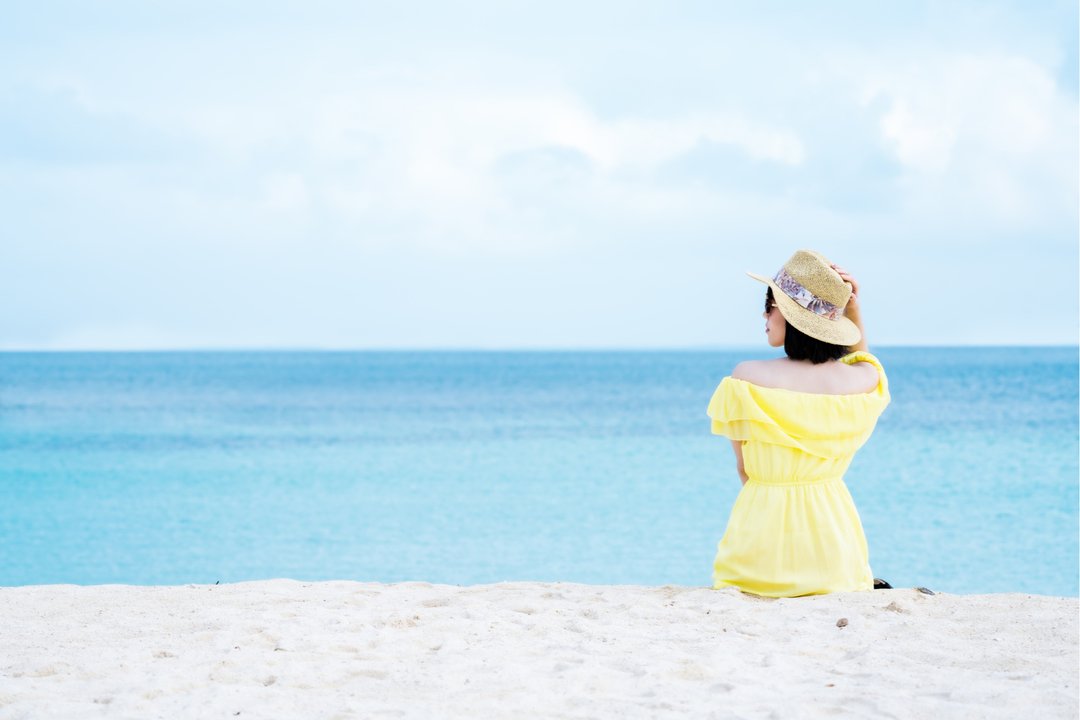 夏、海辺に座っている女性