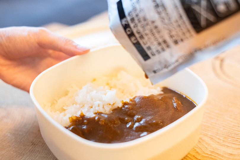 レトルト食品をお皿にそそぐ様子