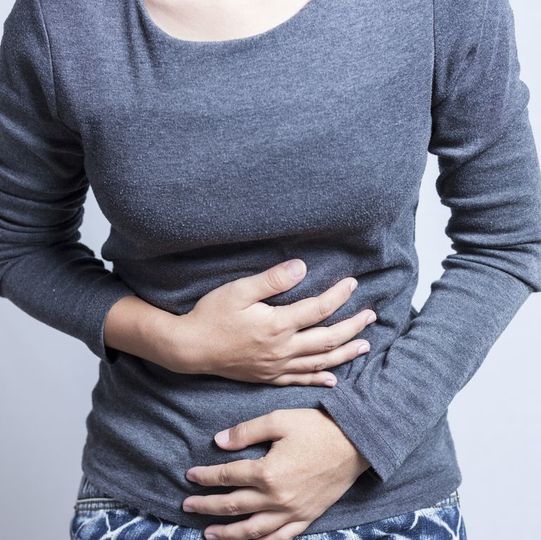 お腹を抑える女性