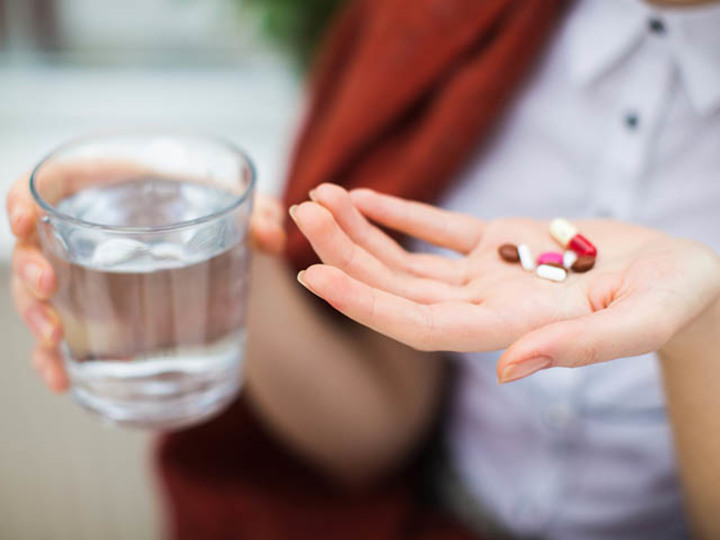 薬を飲む女性