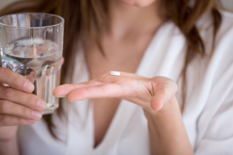 薬を飲む女性