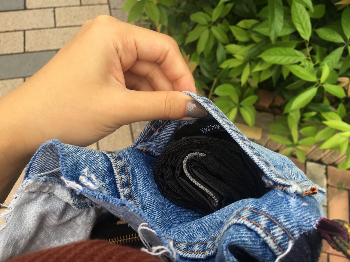 Shupatto「コンパクトバッグ（M）」をサコッシュのポケットに入れ中を見せている