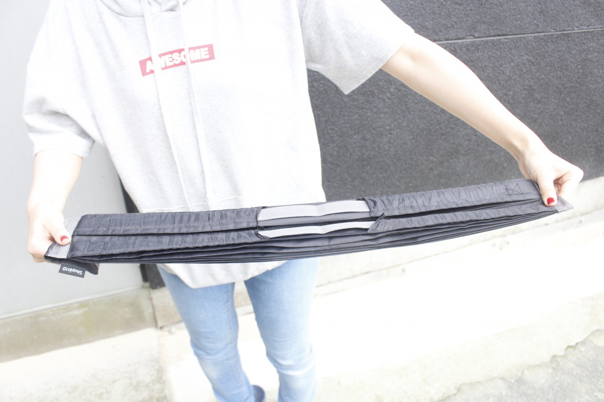 Shupatto「コンパクトバッグ（M）」の両端を引っ張る様子