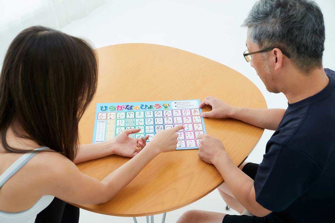 子ども向けのひらがな表を見ながら「この文字は?」「こっちはどう?」と話し合う2人。宮河さん、だんだんマジモードになってきました!
