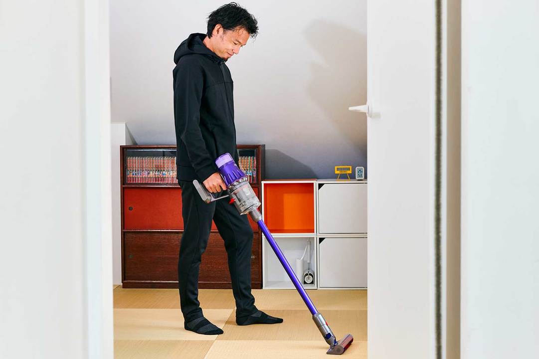 寝室に掃除機をかけているトレーナー・菅原順二さん