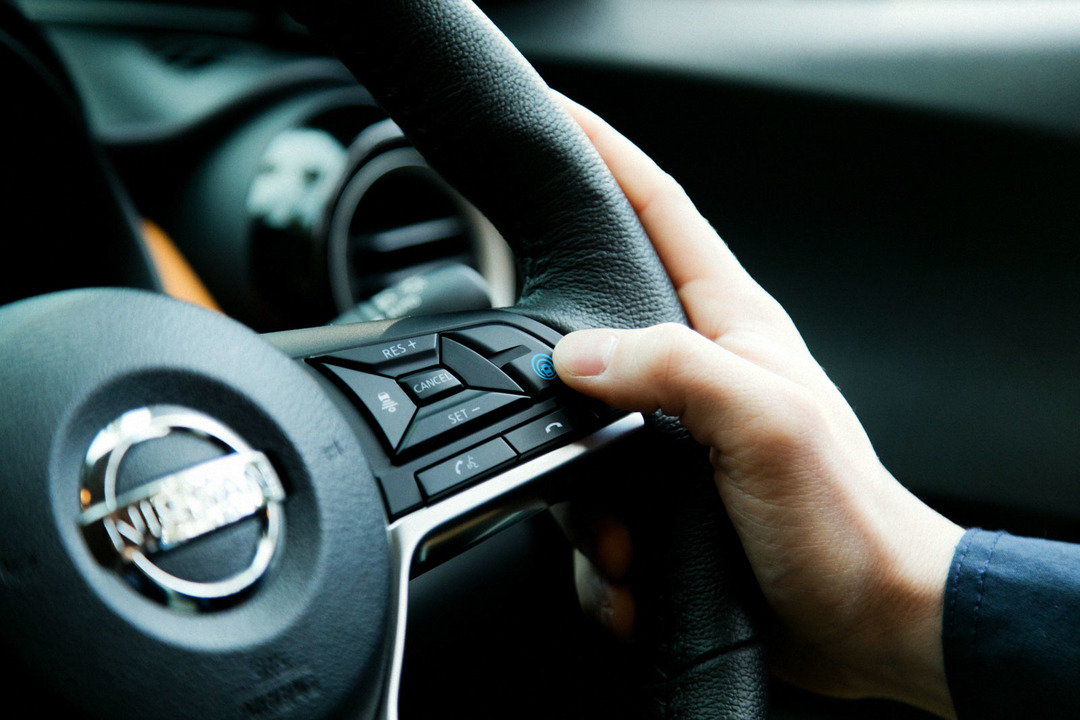日産《キックス》の「プロパイロット」の起動ボタンに指をかけている様子