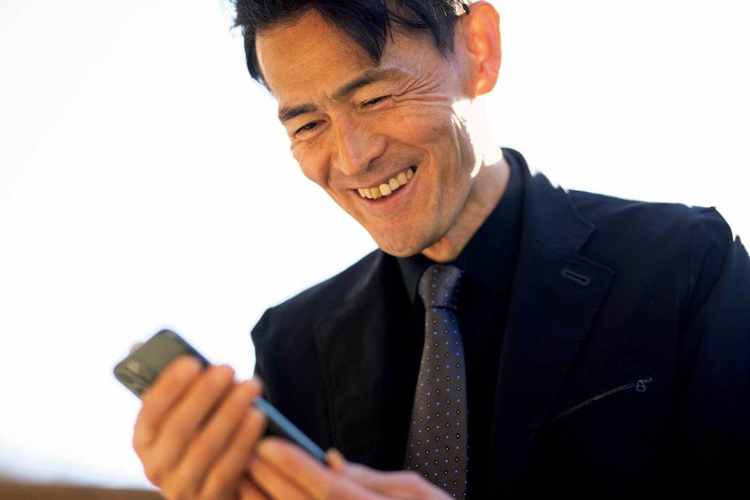 スマートフォンを見る鏑木毅さん